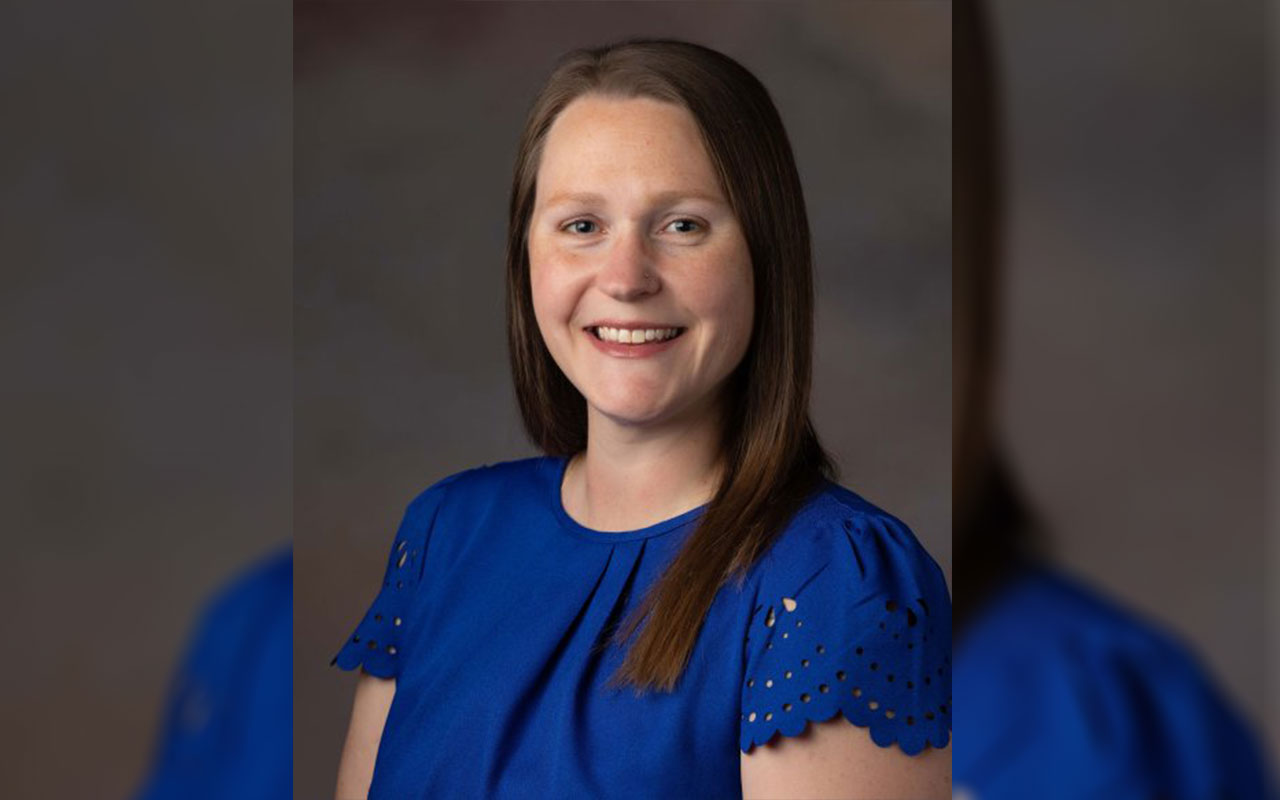 Woman with long brown hair and blue shirt