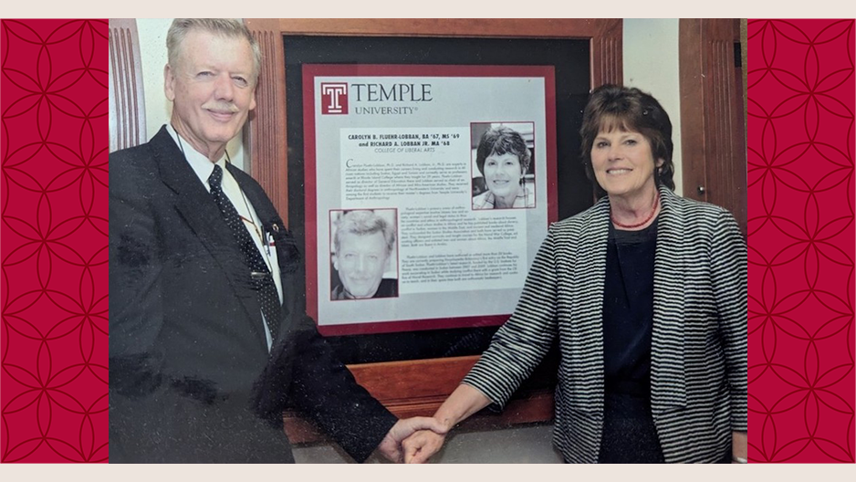 iamge of Richard and Carolyn Lobban holding hands in front of a plaque dedicated to them on Temple's campus