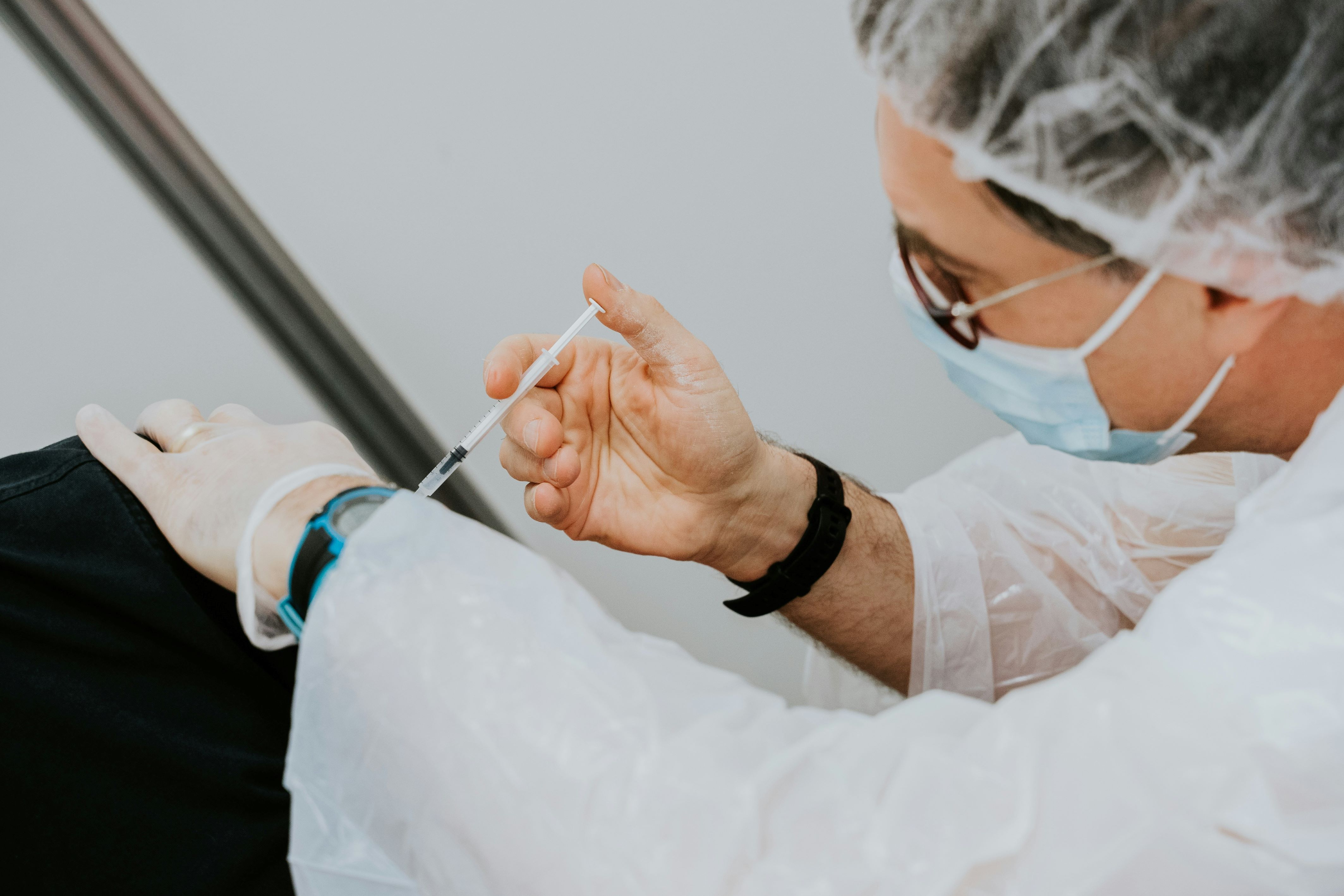 Masked health worker administers an injection