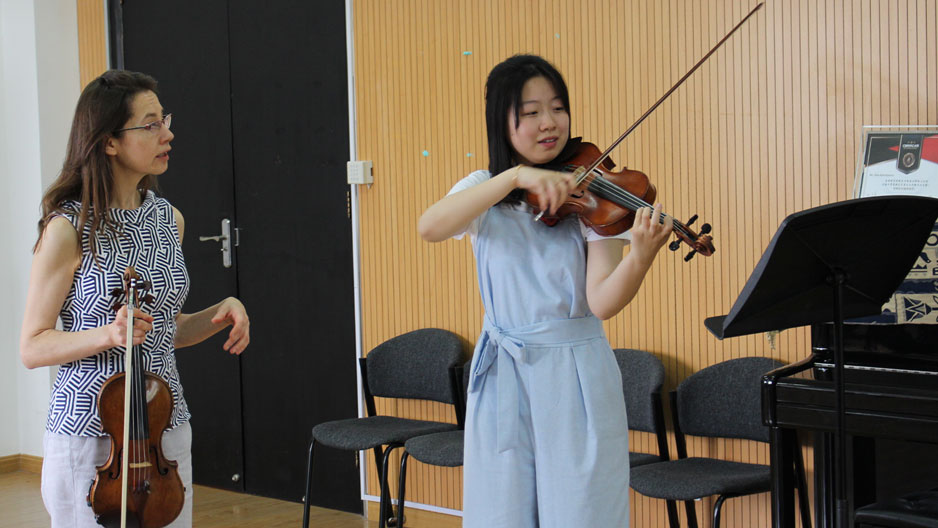 A Boyer professor instructing a student in violin