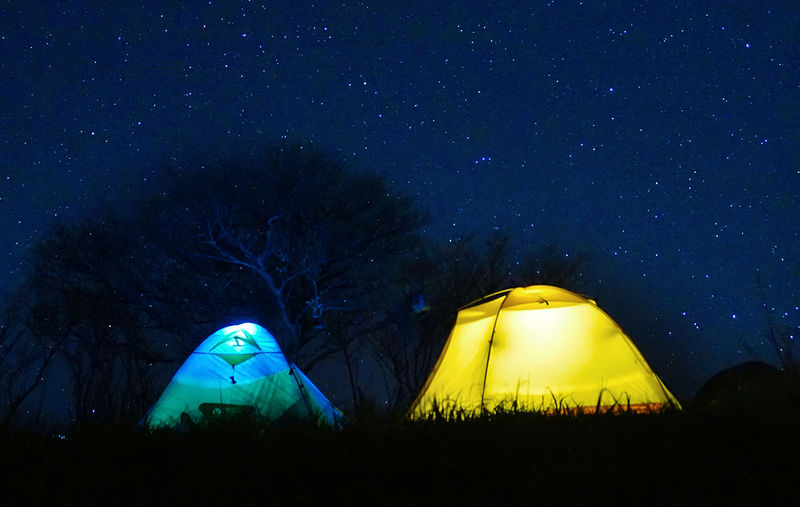 Lit tents against a night sky