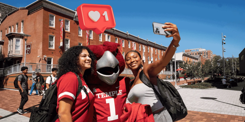 Students posing for a selfie with Hooter