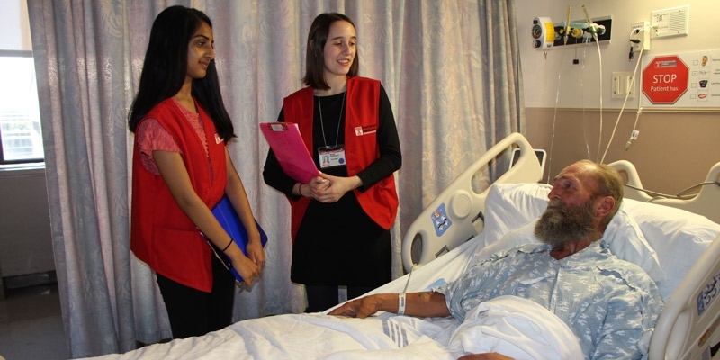 Two patient ambassador students talking with a patient