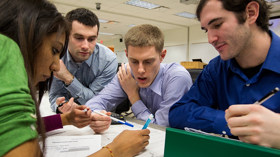 Four students around a table working on an assignment.