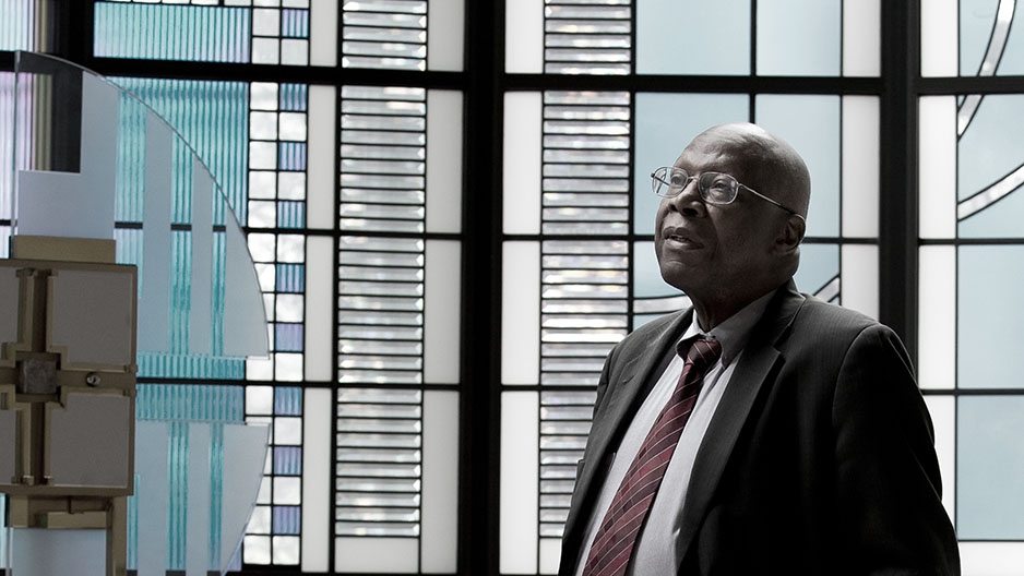 Johnny Young standing in front of a stained glass window.