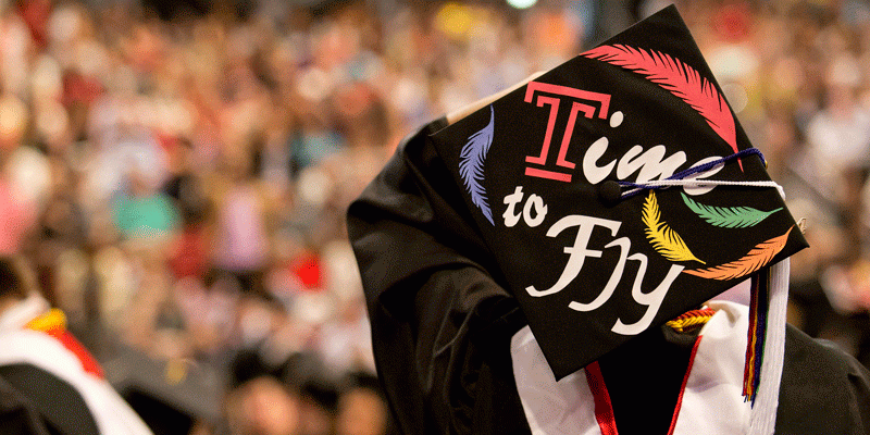 A graduation cap that reads "time to fly"