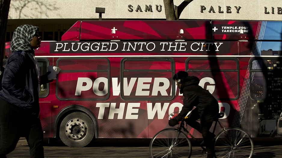 A Temple bus wrap that reads ‘plugged into the city, powering the world’ outside of Paley library.