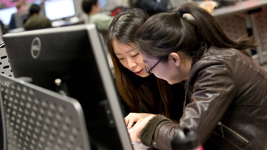 Two women sitting in front of a computer