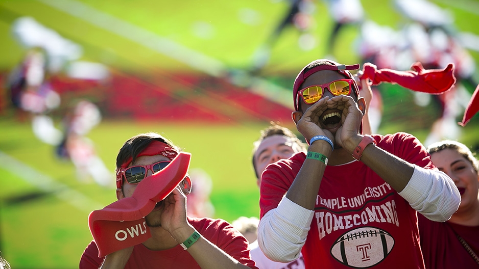 Two students cheering at a football game. 