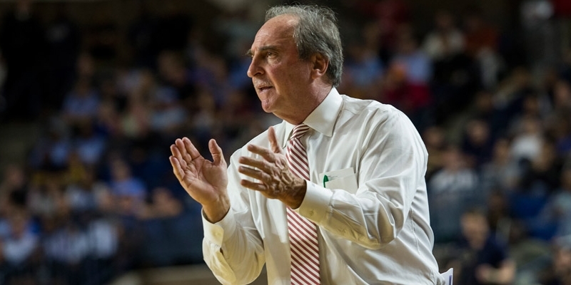 Coach Dunphy coaching from the sideline of a basketball court.