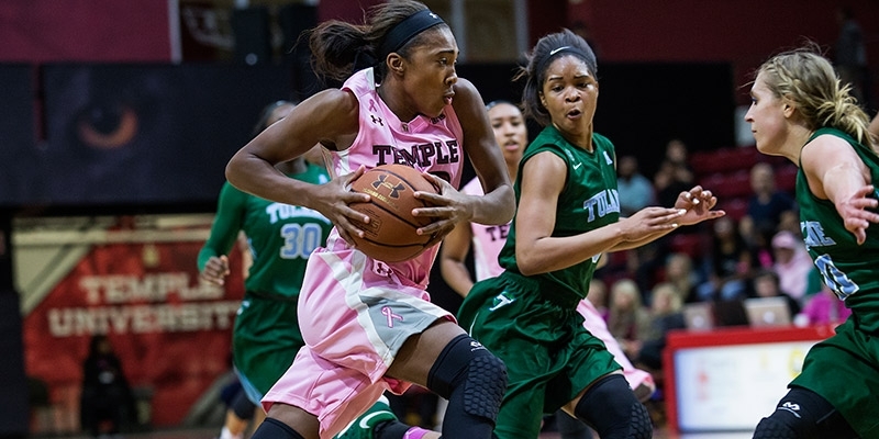 A Temple women’s basketball player holding the ball while making a play.