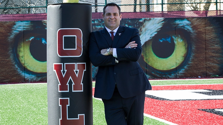 Patrick Kraft leaning against a pole on Temple’s practice football field.