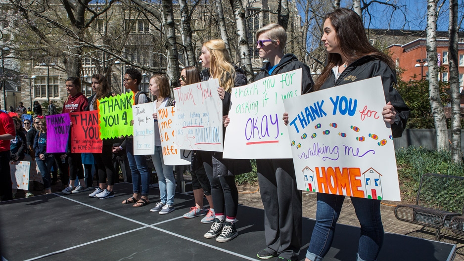 Students holding signs during a walk to raise awareness around sexual assault. 