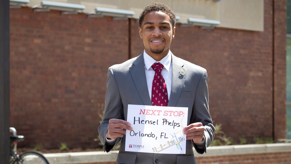 A man wearing a Temple “T” tie, standing in front of the engineering building.