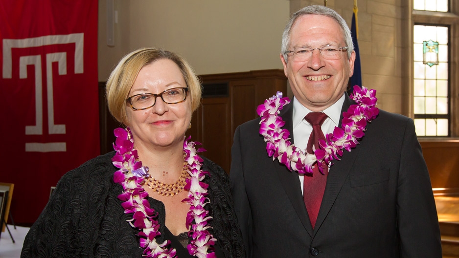 Elizabeth Bolman and President Neil D. Theobald wear flower leis and smile.