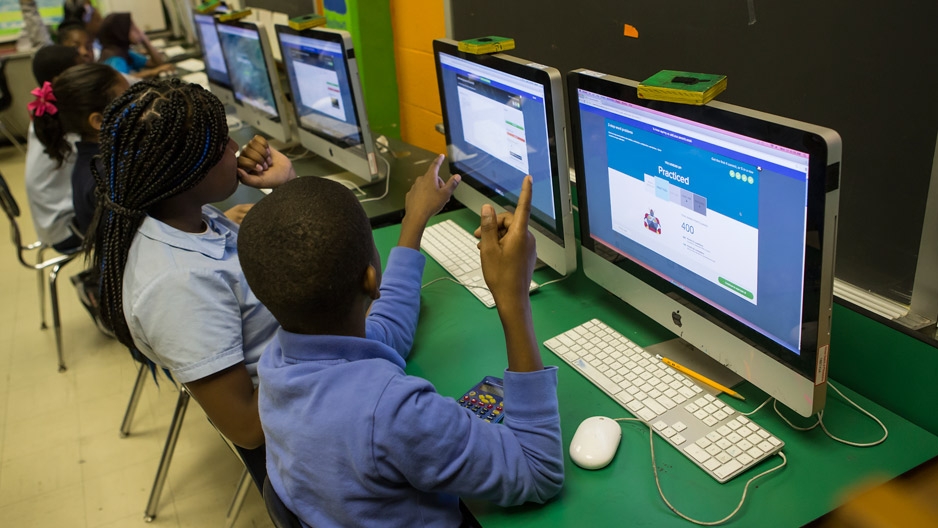 A boy and girl student working at a computer. 