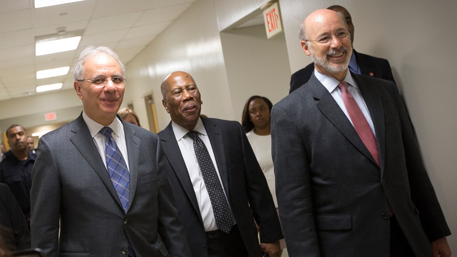 Three men in suits touring the new medical suite at Temple’s dental school. 