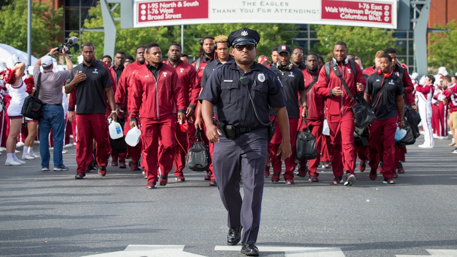 a Temple University police officer escorting football players as they walk into Lincoln Financial Field.