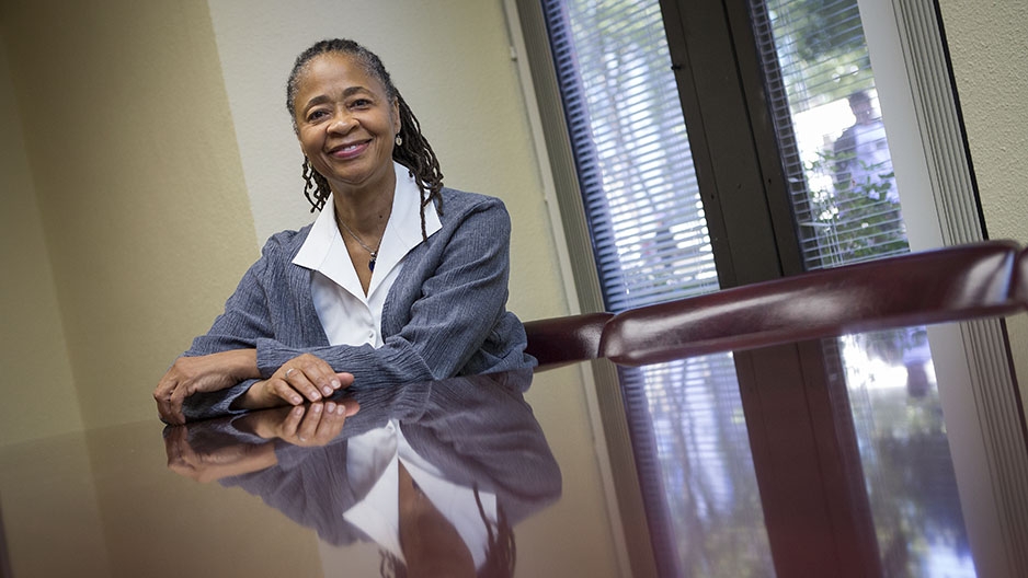 Renee Kirby sitting at a large table smiling.