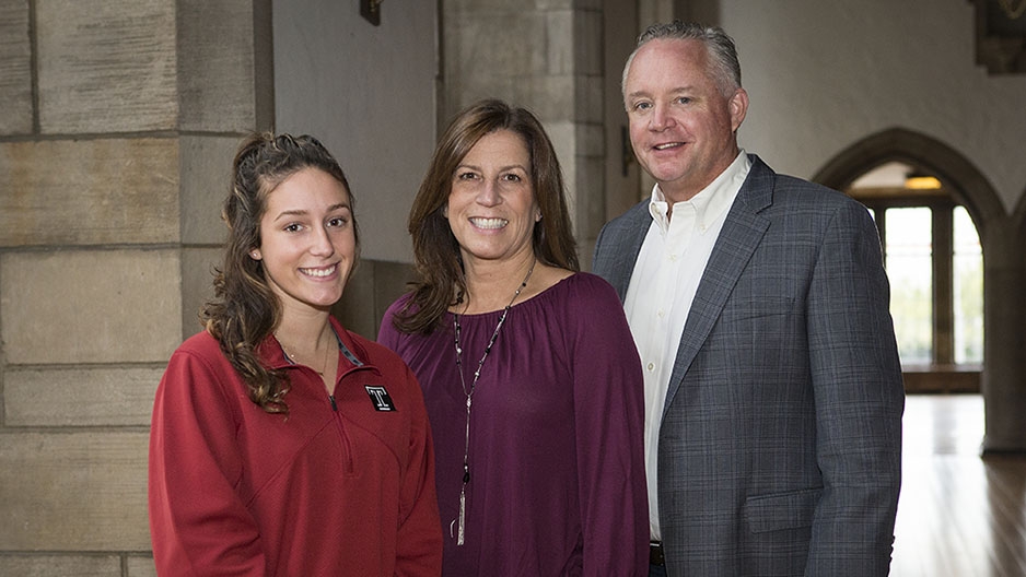 Three members of the Ewell family standing together and smiling. 