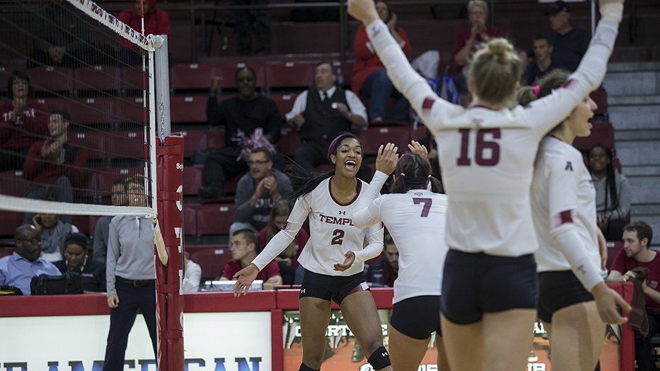 Temple's volleyball team cheering on the court.