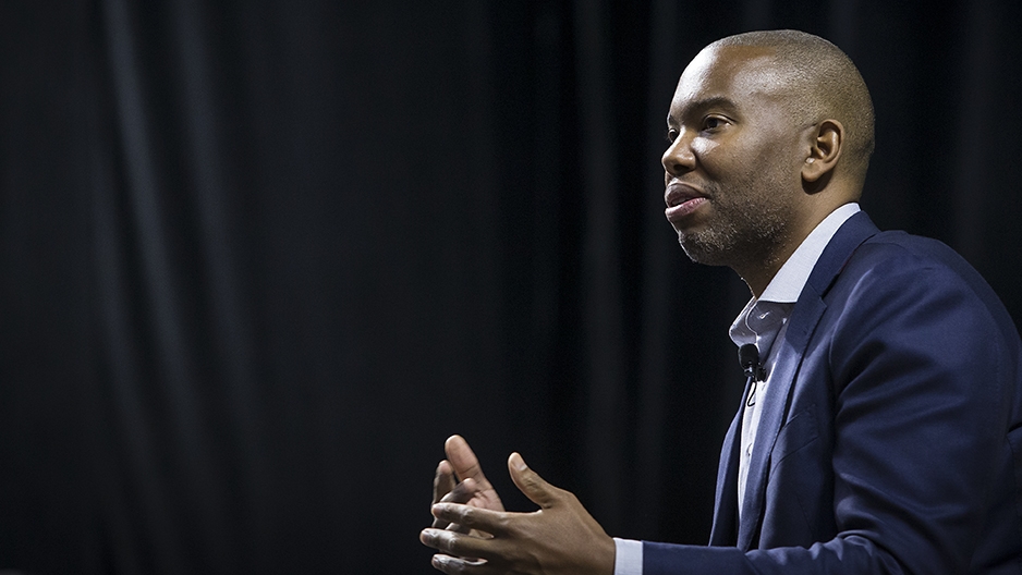 Ta-Nehisi Coates talking with a black curtain behind him. 