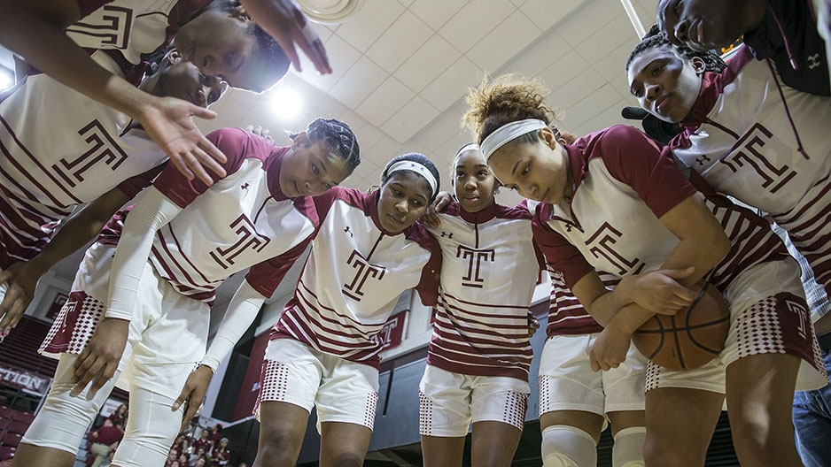 The women’s basketball team having a team huddle.