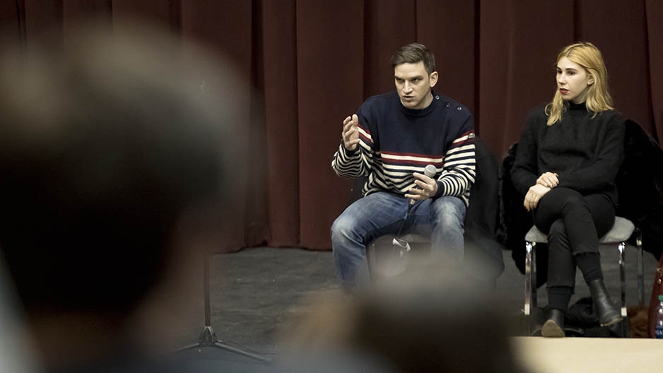 Zosia Mamet and Evan Jonigkeit sitting on stage talking to an audience of students. 