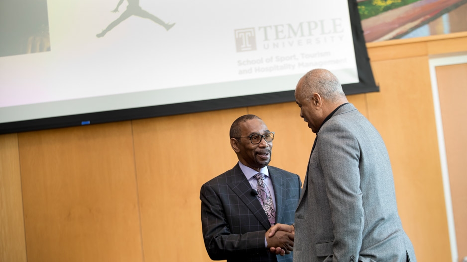 Larry Miller shaking hands with Temple's Jeffery Montague