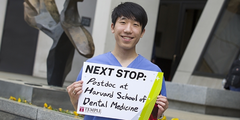 Andy Lee holding a sign that says "Next stop: postdoc at Harvard School of Dental Medicine." 