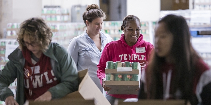 Volunteers working together to package food.  