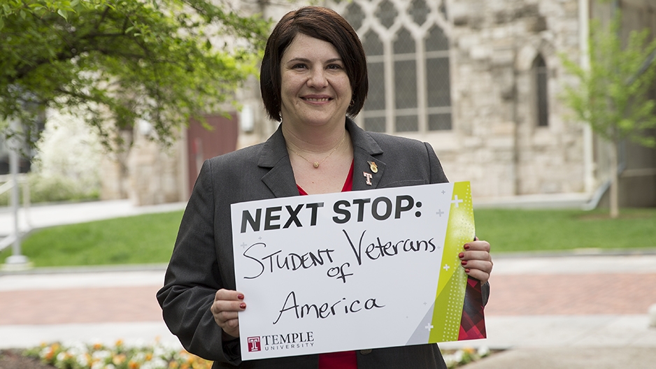 Tammy Barlet holding a sign that says "Next stop: Student Veterans of America."
