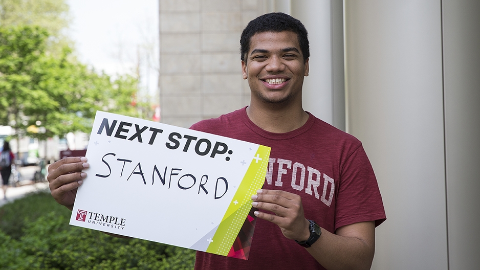 Chey Jones holding a sign for his next stop, Stanford University.