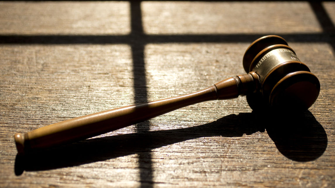 A gavel rests in a patch of sunlight.