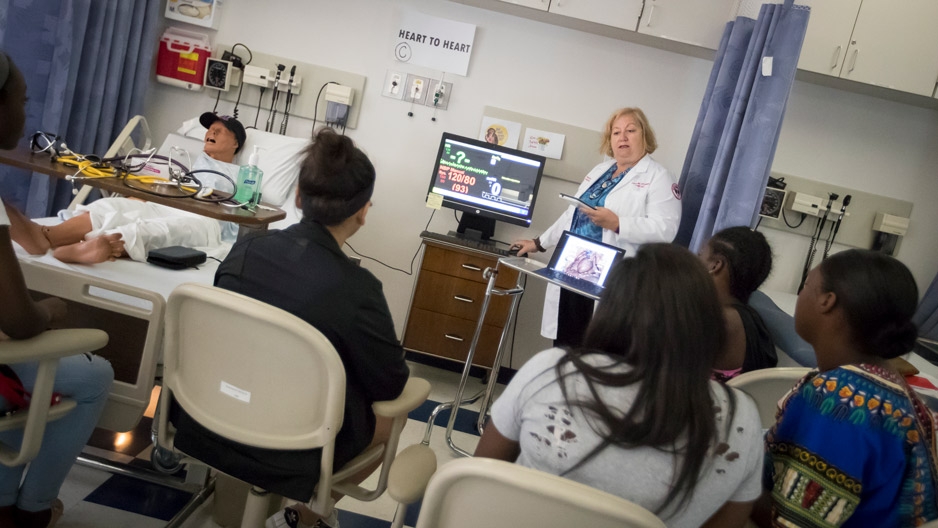a nurse teaching students in a hospital room