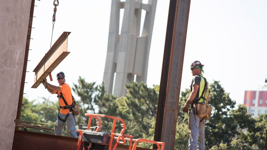 Construction workers place steel beams on Temple’s new library.