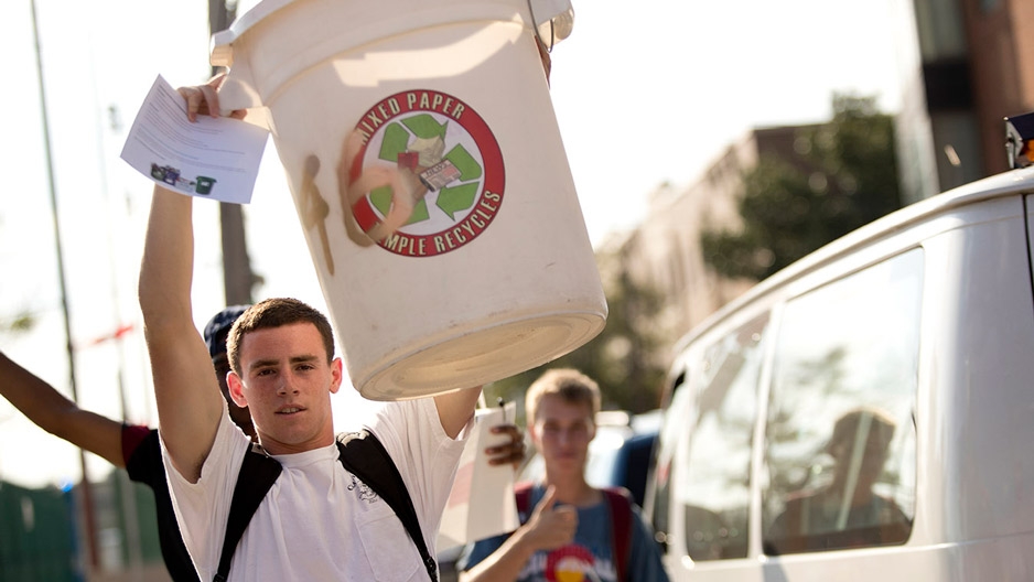 a student holding up his recycling bin