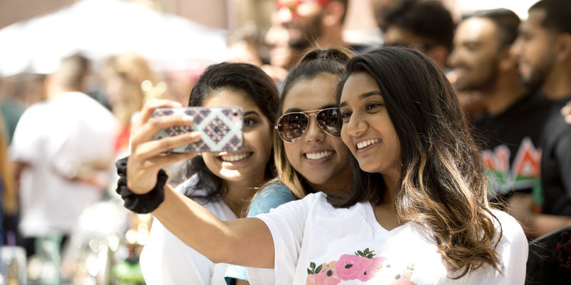 Students taking a selfie together outside