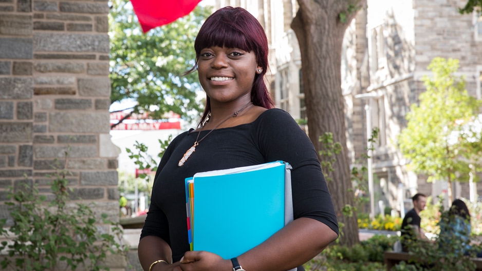 Briana Drummer, a former foster care youth, smiles outside Sullivan Hall at Temple University.