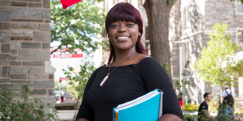 Briana Drummer, a former foster care youth, smiles outside Sullivan Hall at Temple University.