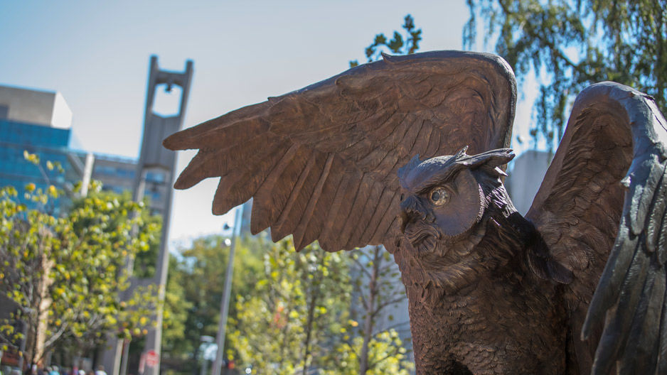 The new owl statue on campus with the Bell Tower in the background