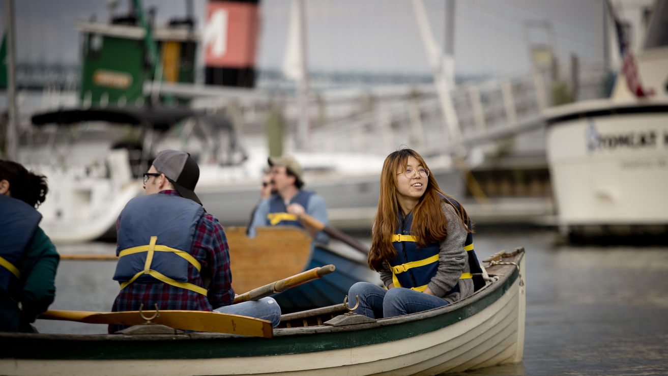 students and professor on a row boat