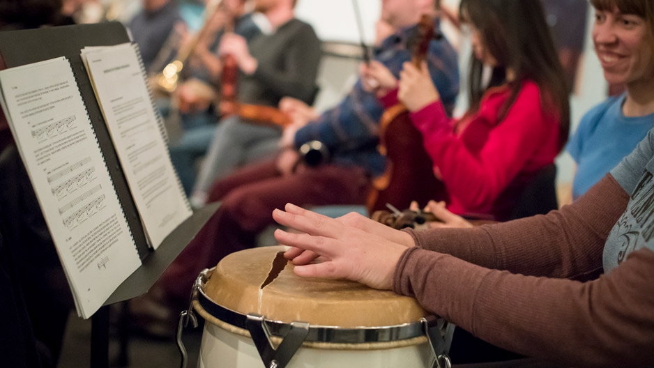 Hands holding a drum with a slit in it