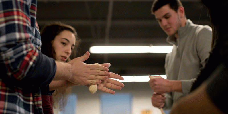 students rolling dough for challah bread