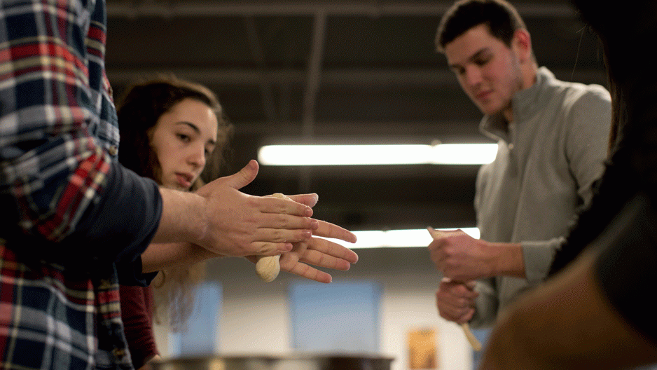 students rolling dough for challah bread