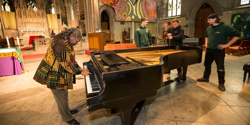 The Rev. Renee McKenzie plays a piano donated by Temple