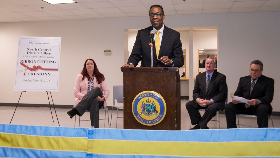 A man wearing a business suit standing at a podium.