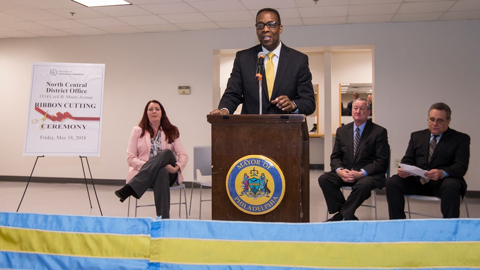 A man wearing a business suit standing at a podium. 