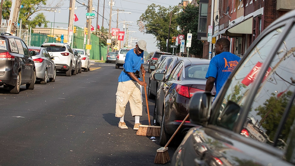 men cleaning the street near Temple's campus