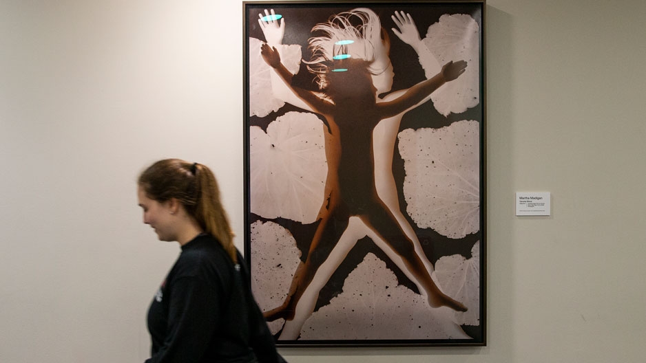 a student walking by artwork